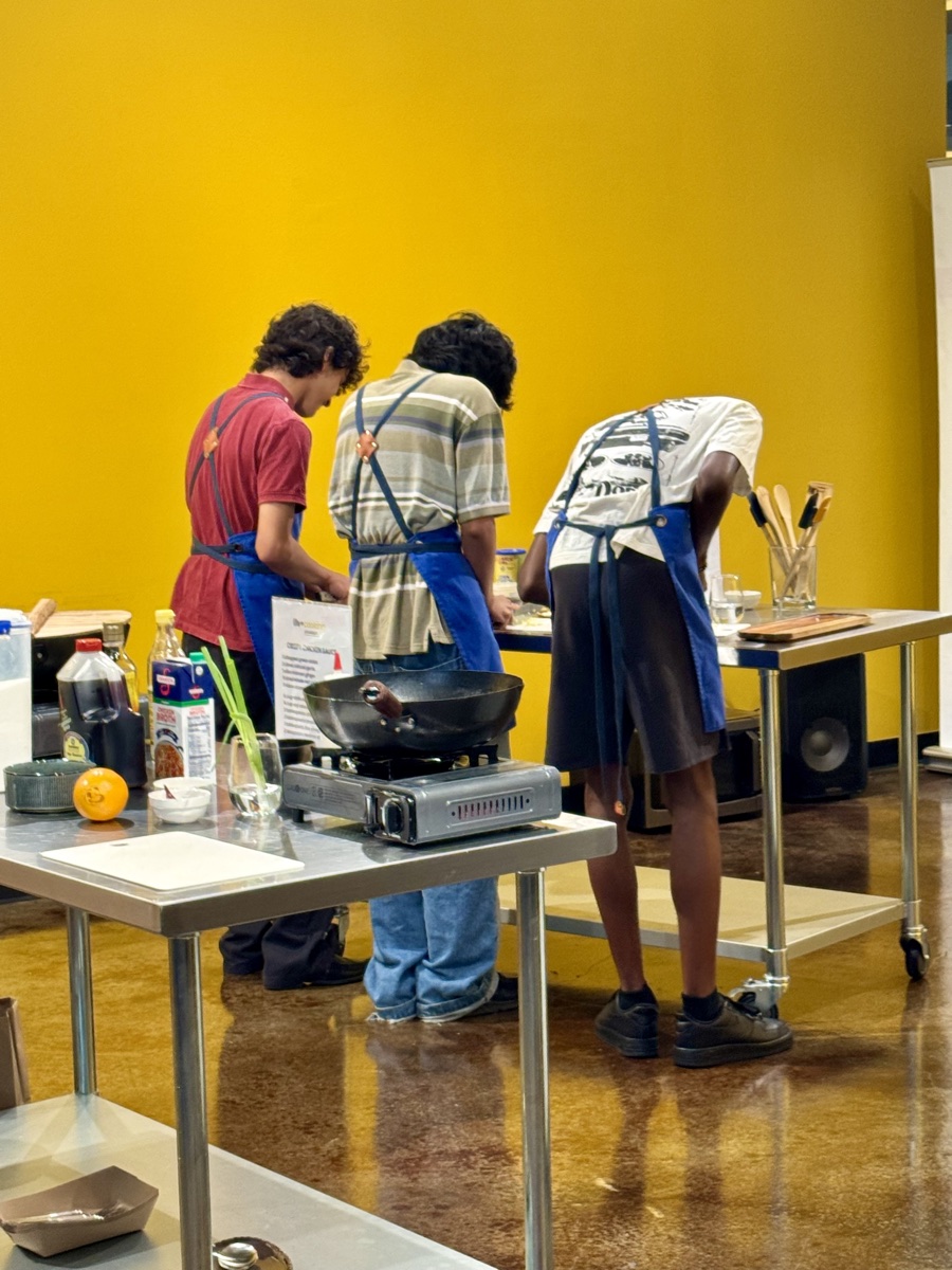 Teens cooking at the stations during an after-school session