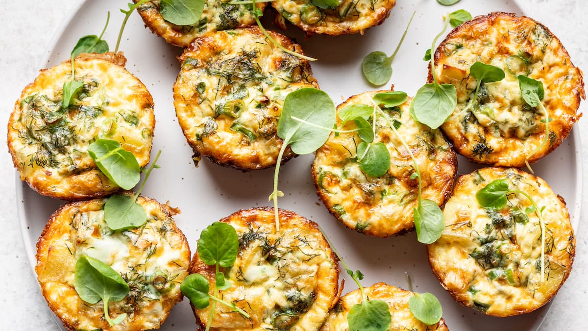 A plate of mini quiches with fresh greens