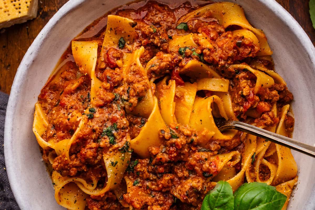 A bowl of pappardelle with meat ragù, basil and Parmesan