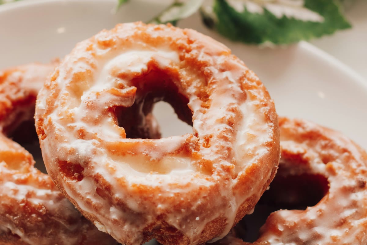 Glazed old-fashioned donuts stacked on a plate