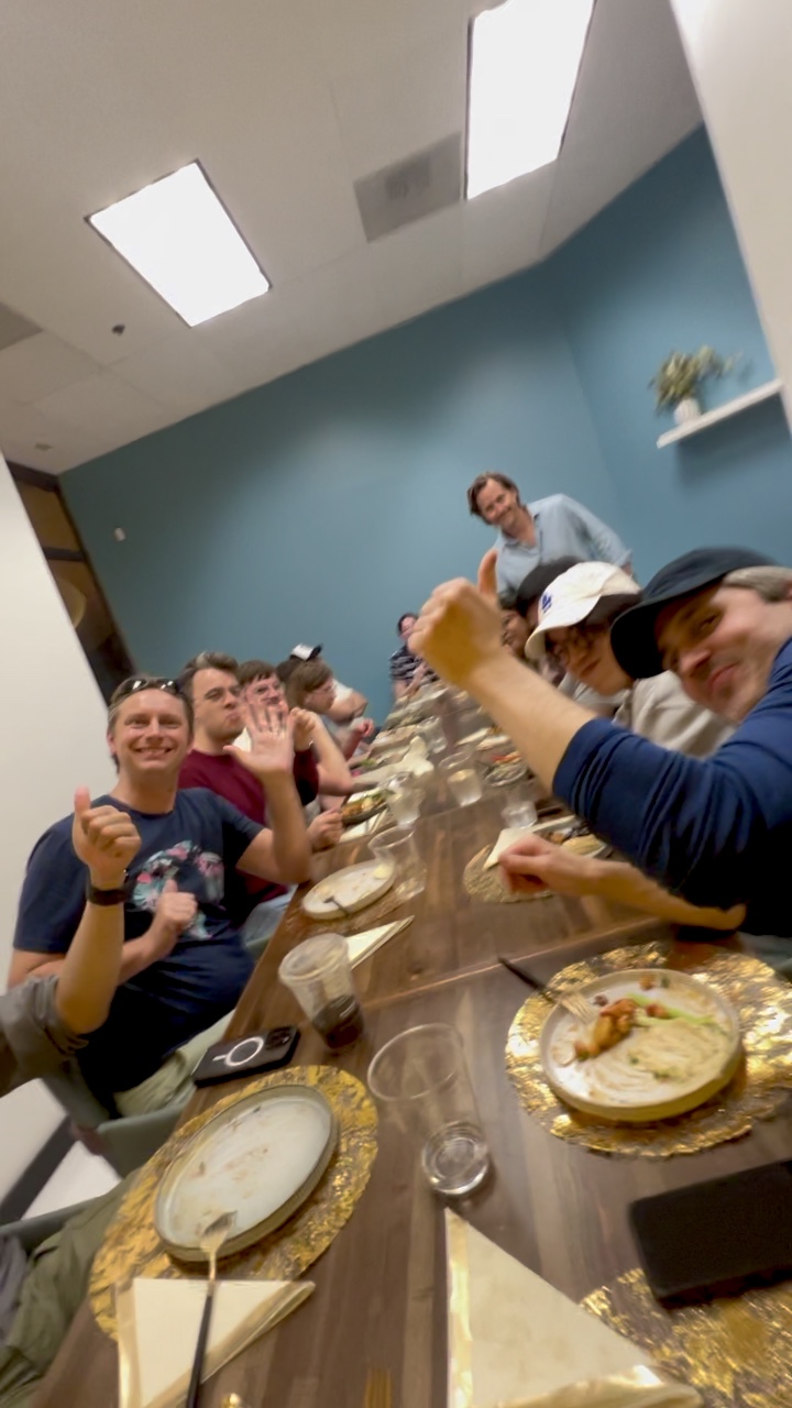 Guests laughing around the long table at a Life Plus supper club